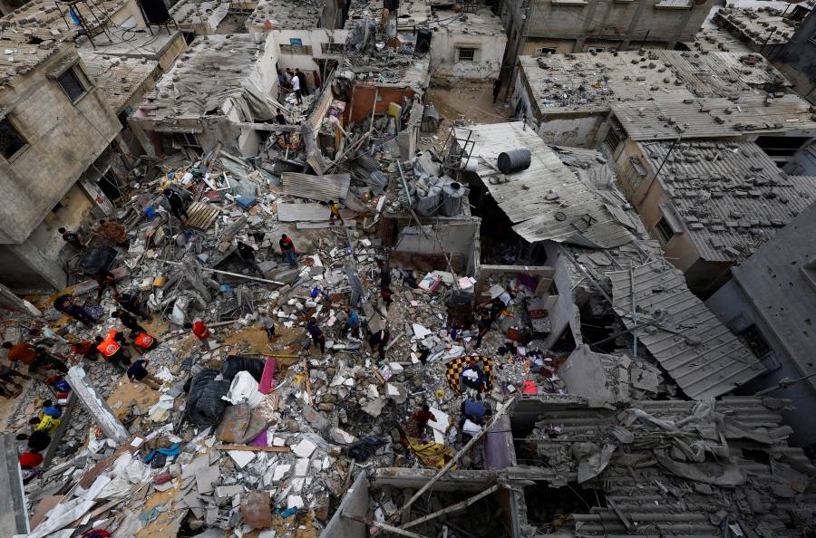 مواطنون يتفقدون الأضرار في موقع الغارات الإسرائيلية على المنازل في خان يونس جنوب قطاع غزة